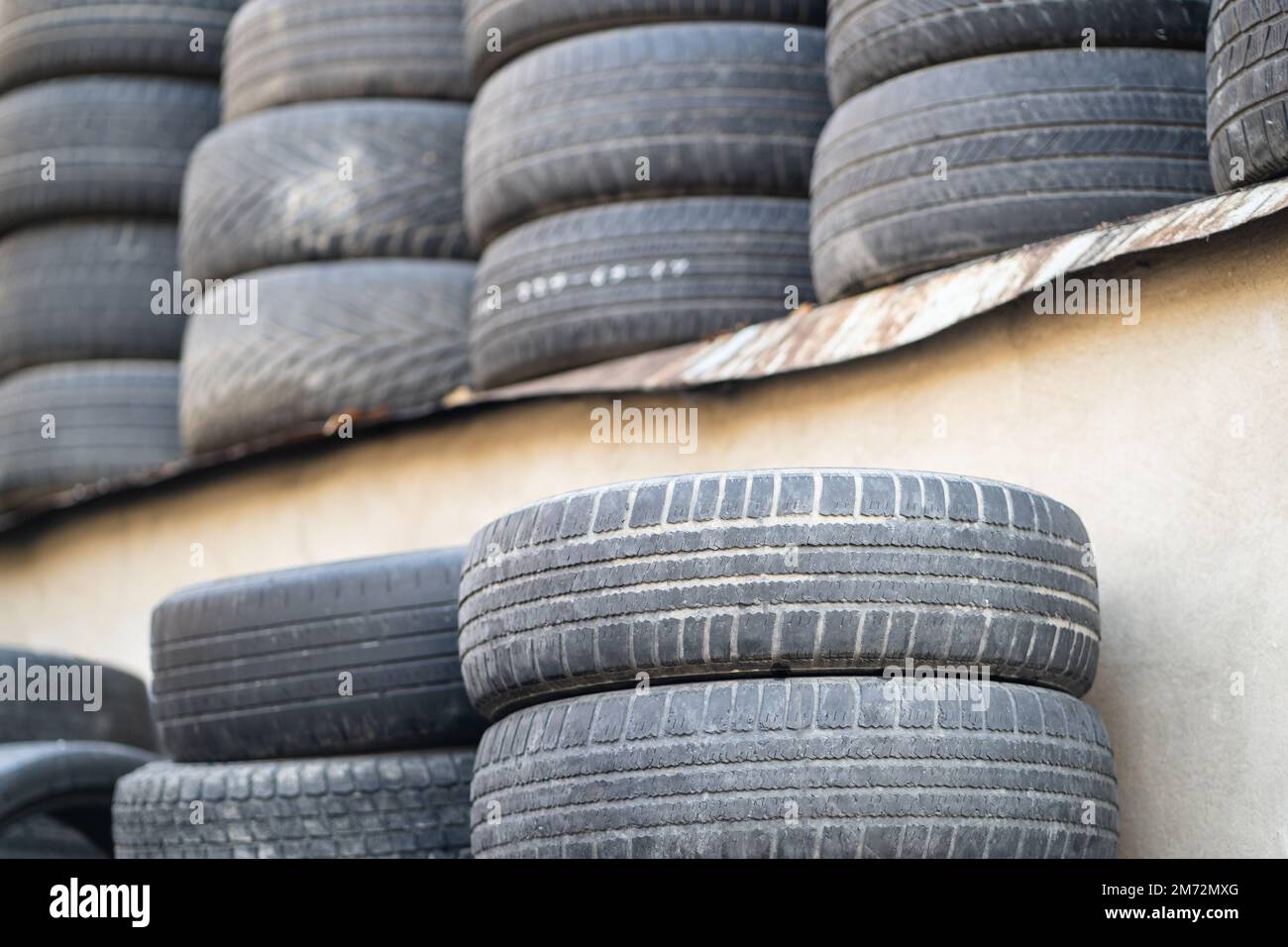 Vecchi pneumatici di gomma usati impilati con pali alti. Rifiuti pericolosi  che richiedono il riciclaggio e lo smaltimento Foto stock - Alamy