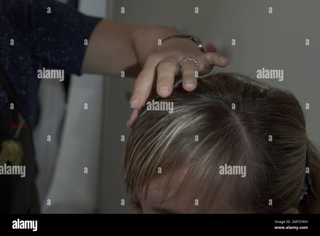 Il parrucchiere sente la consistenza dei capelli con la mano prima di tagliare Foto Stock