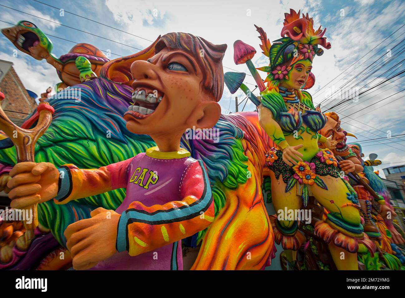 Grandi carri sfilano accanto a comparsas l'ultimo giorno del carnevale multicolore del confine. Ipiales, Nariño, 6 gennaio 2023. Foto Stock