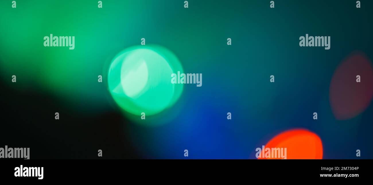 Bokeh multicolore su sfondo scuro. Nuovo anno ghirlanda blured con fondo blurry. Messa a fuoco morbida Foto Stock