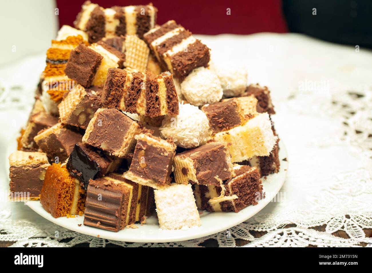 Molti quadrati torte accatastati su una piastra di ceramica bianca, fuoco morbido primo piano Foto Stock