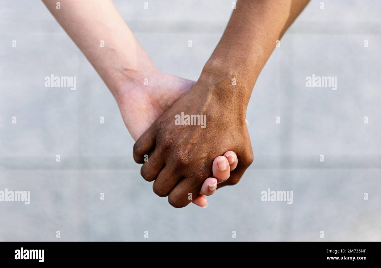 Primo piano di due diverse donne che tengono le mani mostrando unità e sostegno Foto Stock