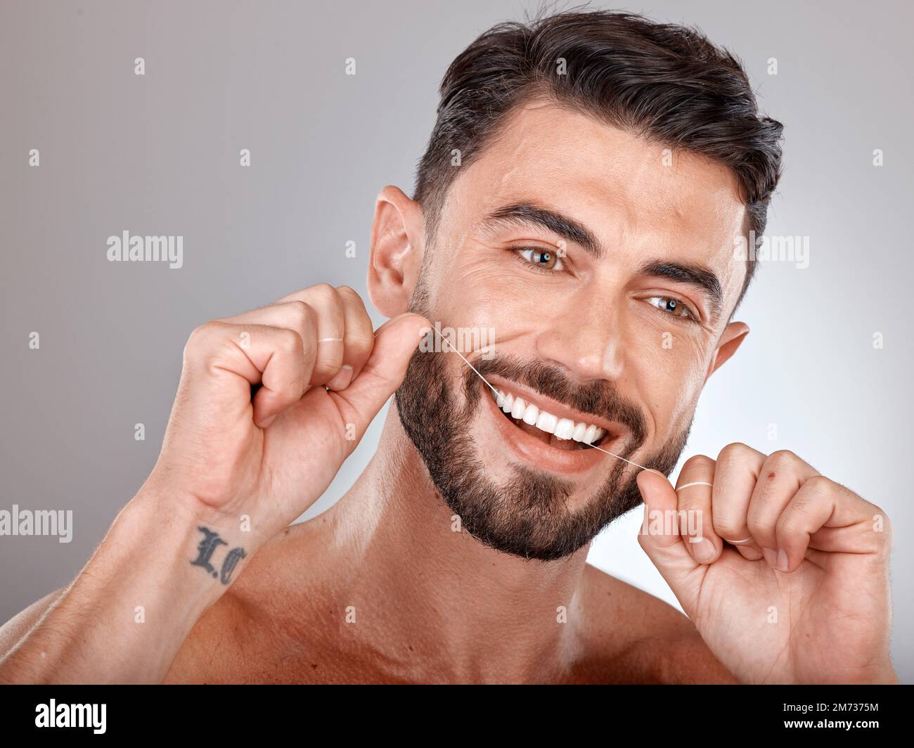 Filo interdentale, denti sbiancanti e uomo felice con uno stile di vita dentale sano, benessere o cura della pelle su sfondo studio. Faccia del modello maschio, galleggiamento dei denti e. Foto Stock