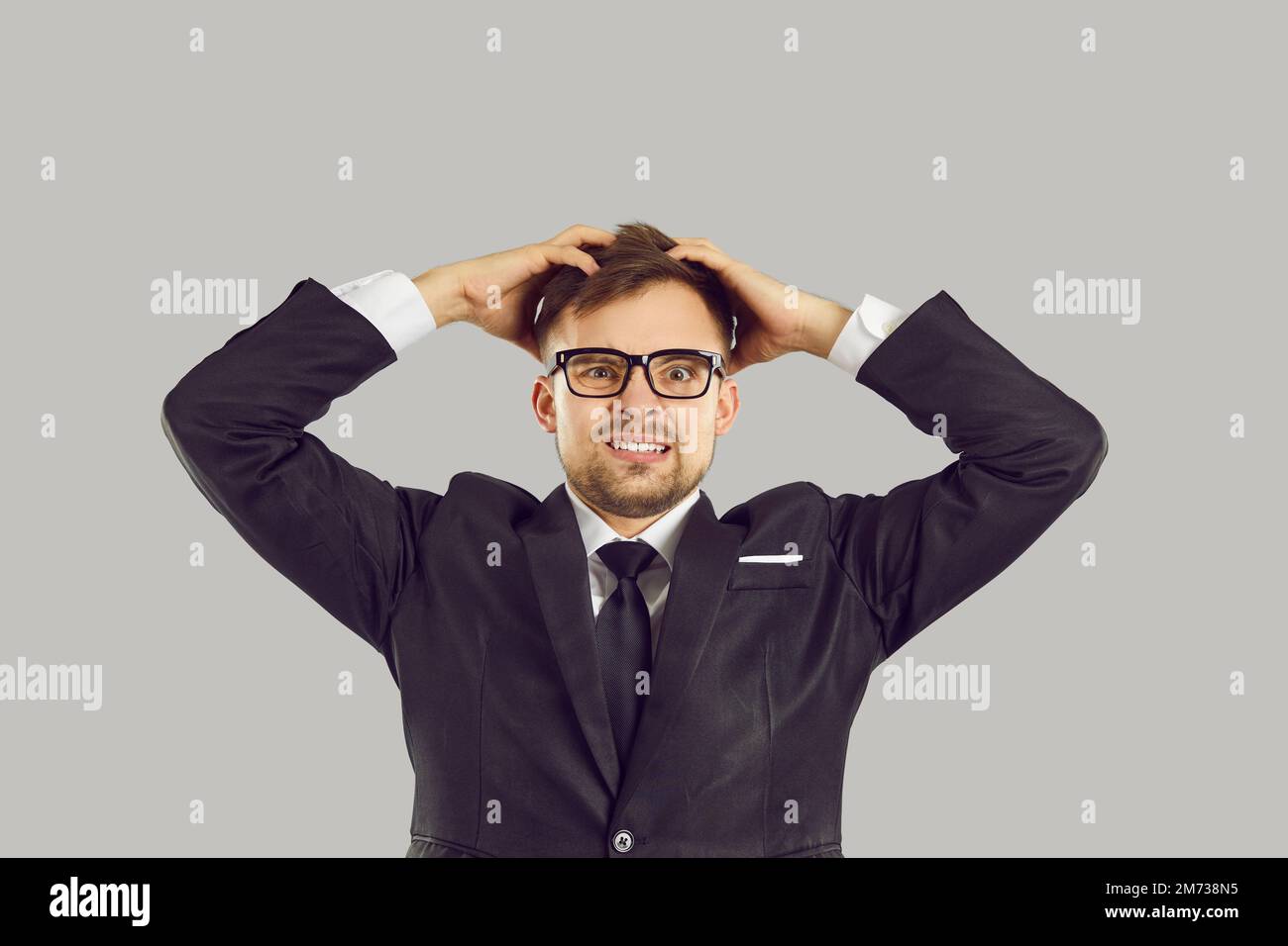 Giovane uomo caucasico imprenditore tenere testa con lo sguardo spaventato a causa di problemi nel business Foto Stock