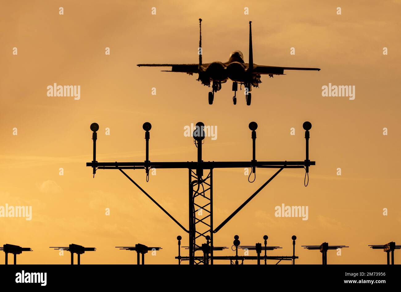 Getto da caccia al tramonto. Moderno jet militare con cielo arancione che ritorna da una missione di combattimento. Foto Stock