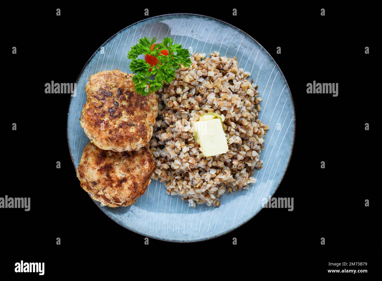 grano saraceno con cotolette di carne su sfondo nero vista dall'alto Foto Stock