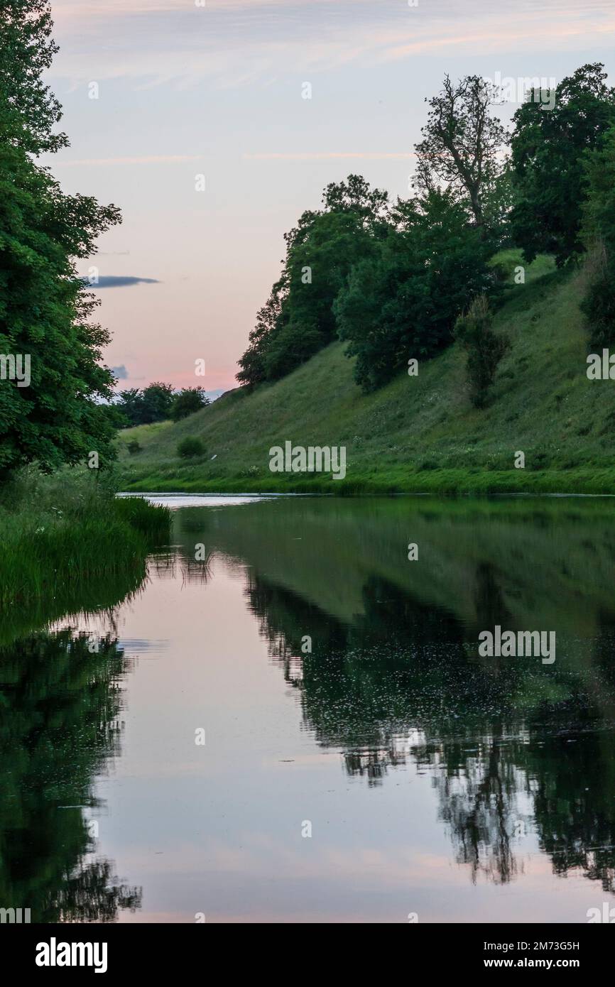 Il fiume Teviot accanto al castello di Roxburgh tumulo dopo il tramonto a tarda sera di luglio (10pm) Foto Stock