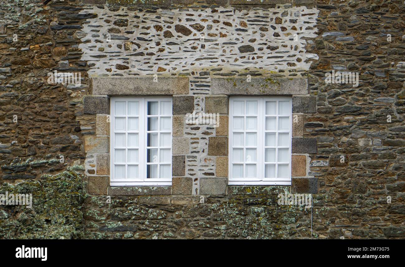 Finestre bianche su un muro di granito a Saint-Malo, Bretagne, Francia Foto Stock