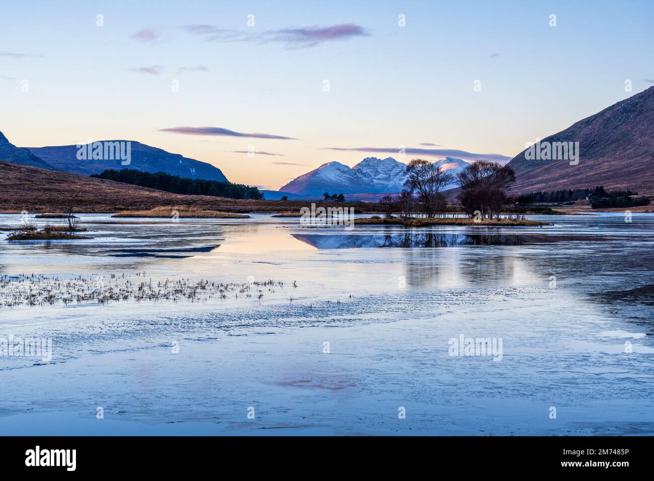 Frozen Loch Droma, con le alture torreggianti di un massiccio montuoso di Teallach in lontananza, Wester Ross, Highland, Scozia, Regno Unito Foto Stock