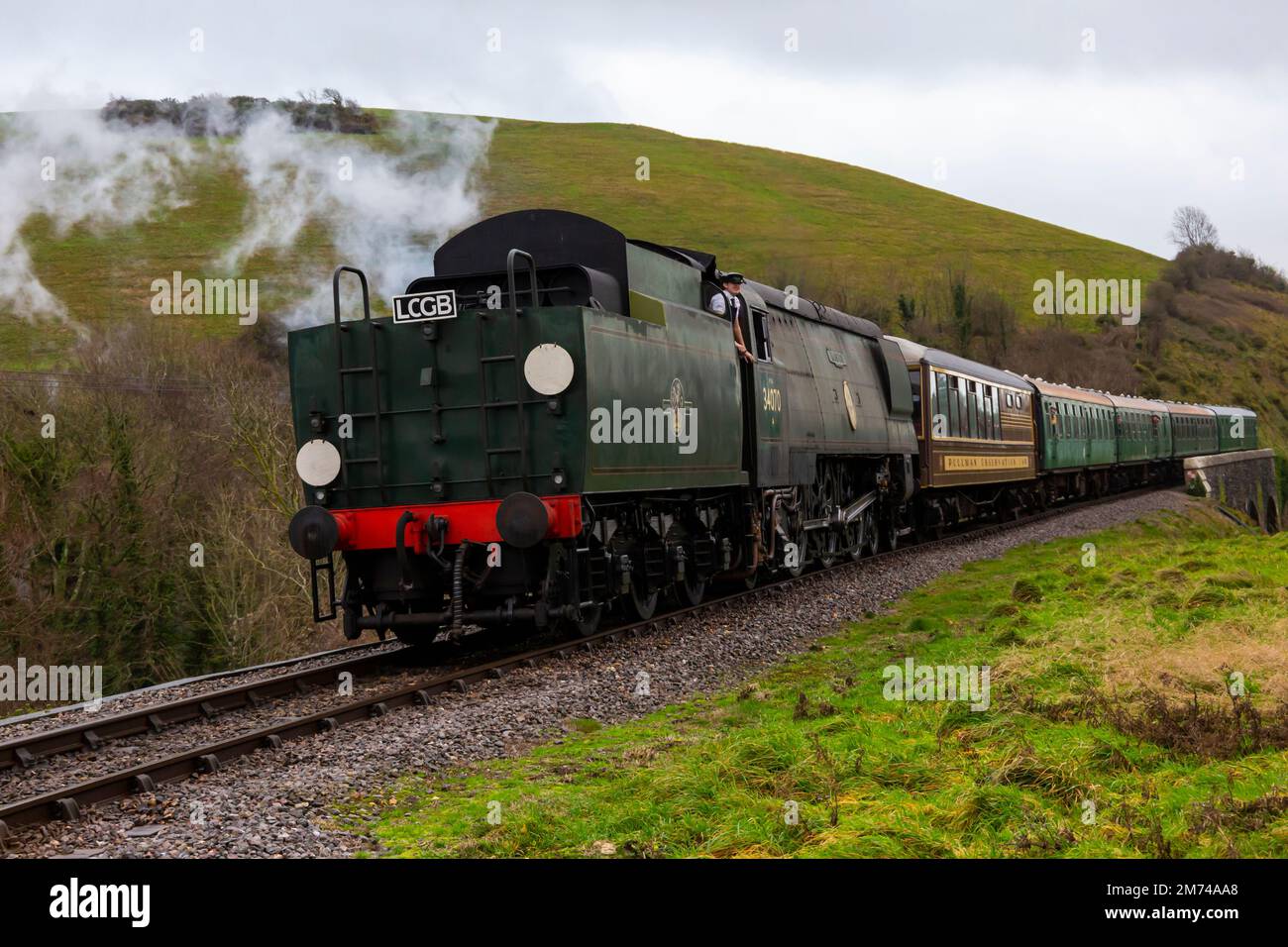 Corfe Castle Dorset, Regno Unito. 7th gennaio 2023. Inverno Warm Up nostalgico evento si svolge durante il fine settimana con una miscela di treni passeggeri a vapore e diesel che viaggiano tra Swanage e Norden. 34070, Manston, treno a vapore viaggia attraverso la splendida campagna del Dorset passando attraverso il castello di Corfe in una giornata grigia umida e ventosa. Credit: Carolyn Jenkins/Alamy Live News Foto Stock