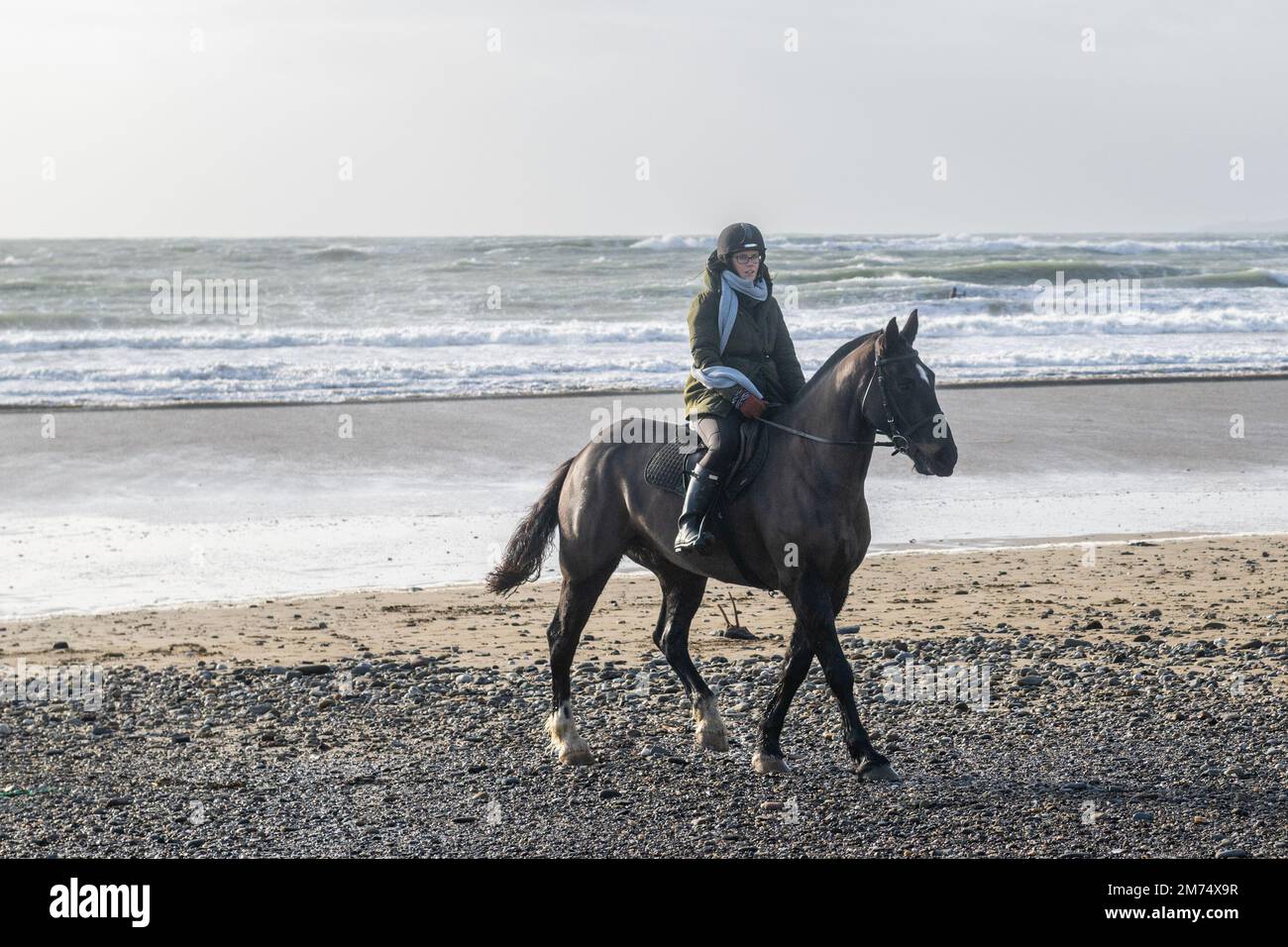 Garrylucas Beach, West Cork, Irlanda. 7th Jan, 2023. Met Éireann ha emesso un avvertimento giallo per cinque contee. L'avvertimento giallo del vento è per le contee Kerry, Clare, Galway, Mayo e Donegal ed è valido fino alle 08,00 di domani mattina (Dom 8th). Prendendo il suo cavallo 'TJ' per un giro sulla spiaggia è stato Alison Chambers da Garretstown. Credit: AG News/Alamy Live News Foto Stock
