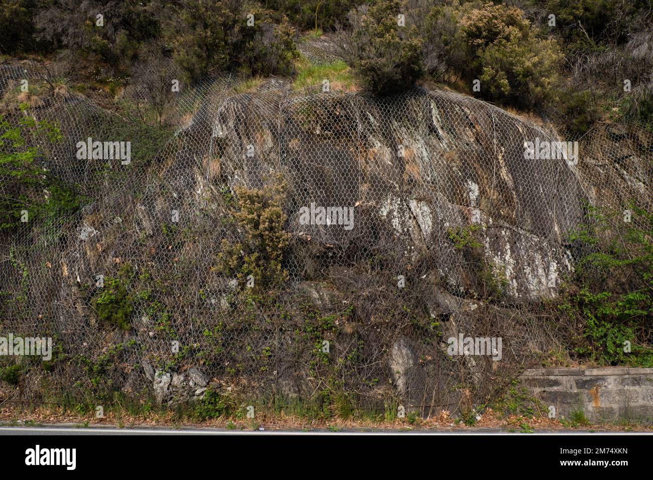 Rete metallica protettiva contro la caduta di rocce. Protezione o cautela su strade di montagna. Foto Stock