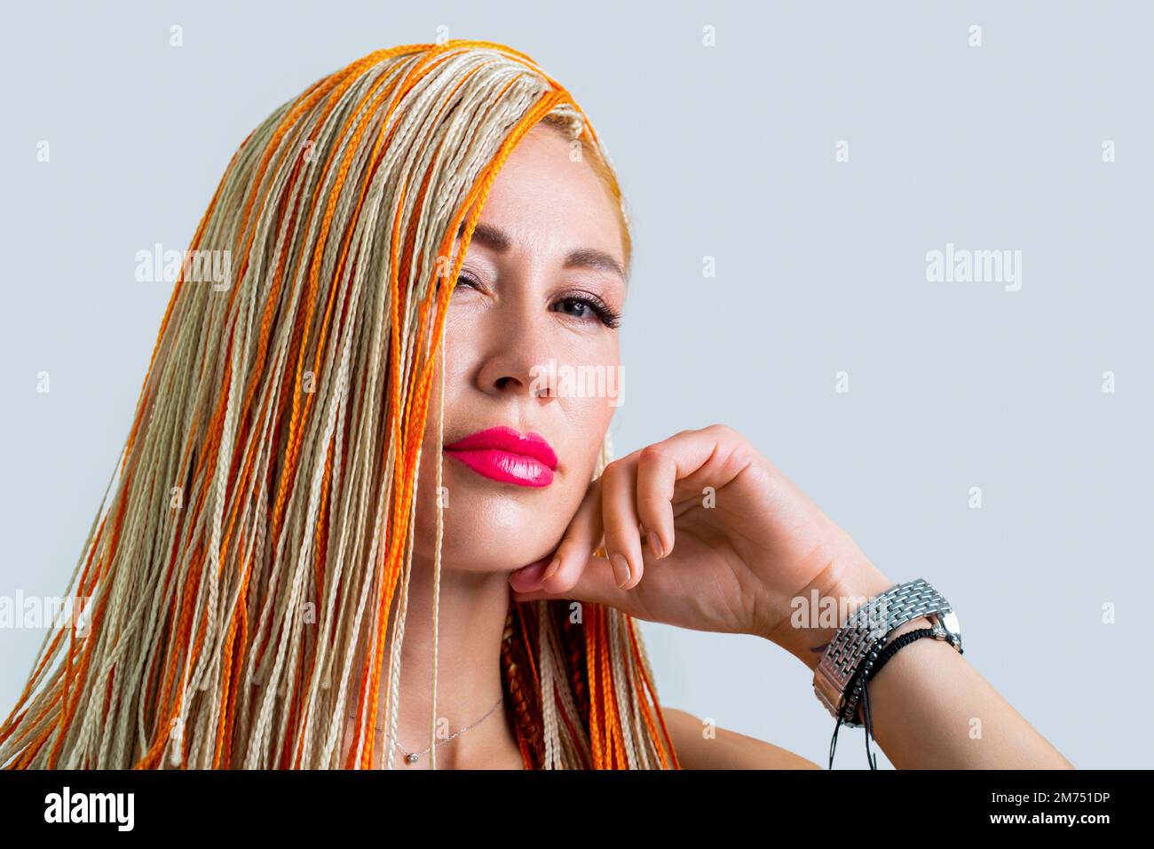 Donna bella colorful trecce di capelli arancioni. Concetto di parrucchiere. Trecce ragazza. Ritratto di bella ragazza giovane con trecce. Donna elegante e bella Foto Stock