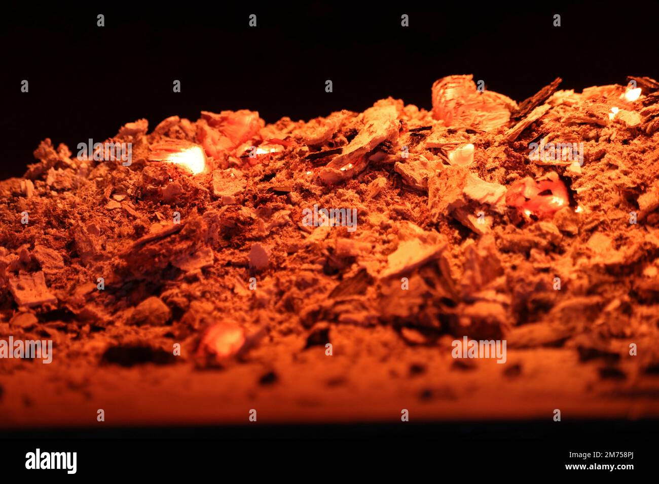 Carbone rosso-caldo e cenere su sfondo nero. Foto Stock