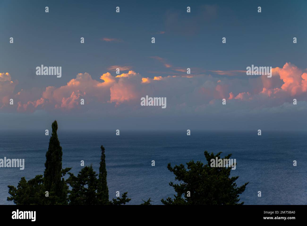 Nuvole rosa al tramonto sul Mar Ionio da Paxos, Grecia Foto Stock