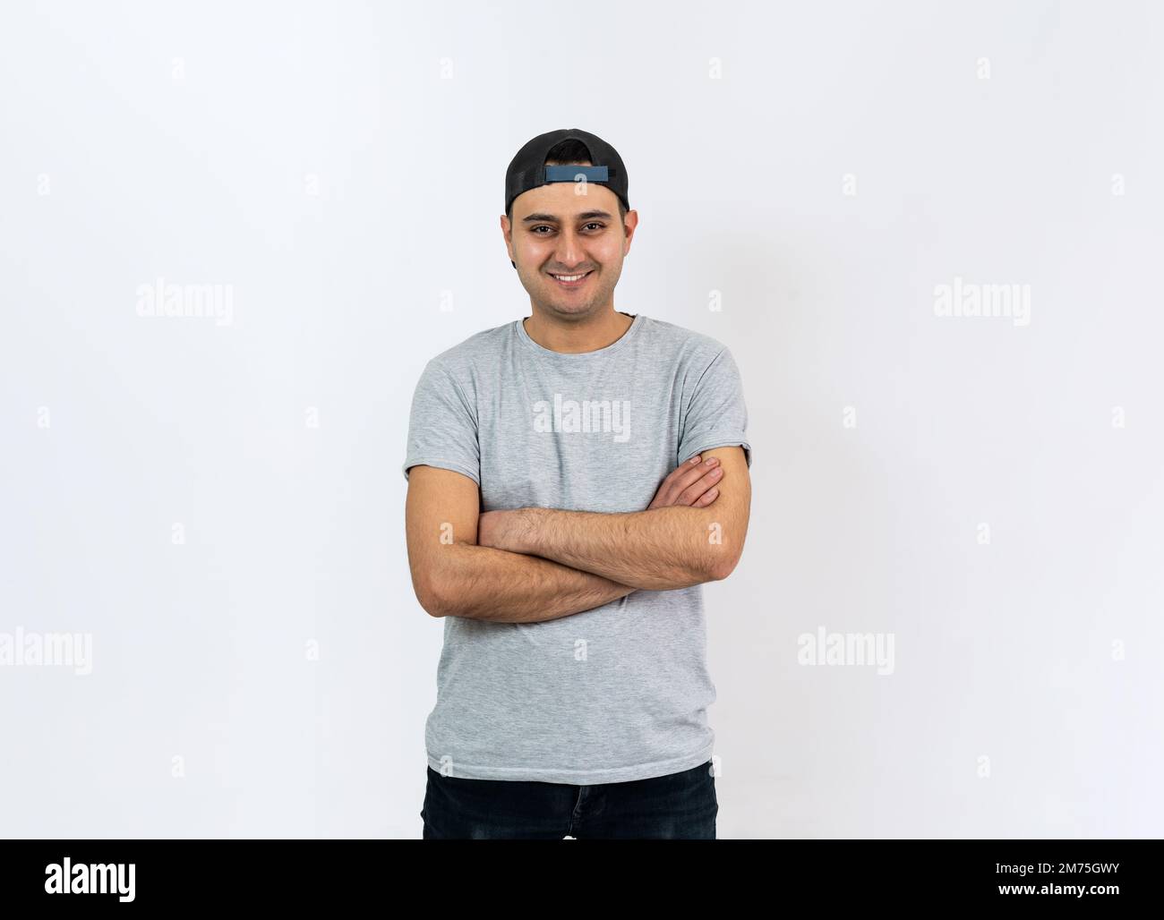 Primo piano foto di studio di un giovane adulto con pelle marrone in piedi e sorridente alla fotocamera. Spazio per il testo. Foto Stock
