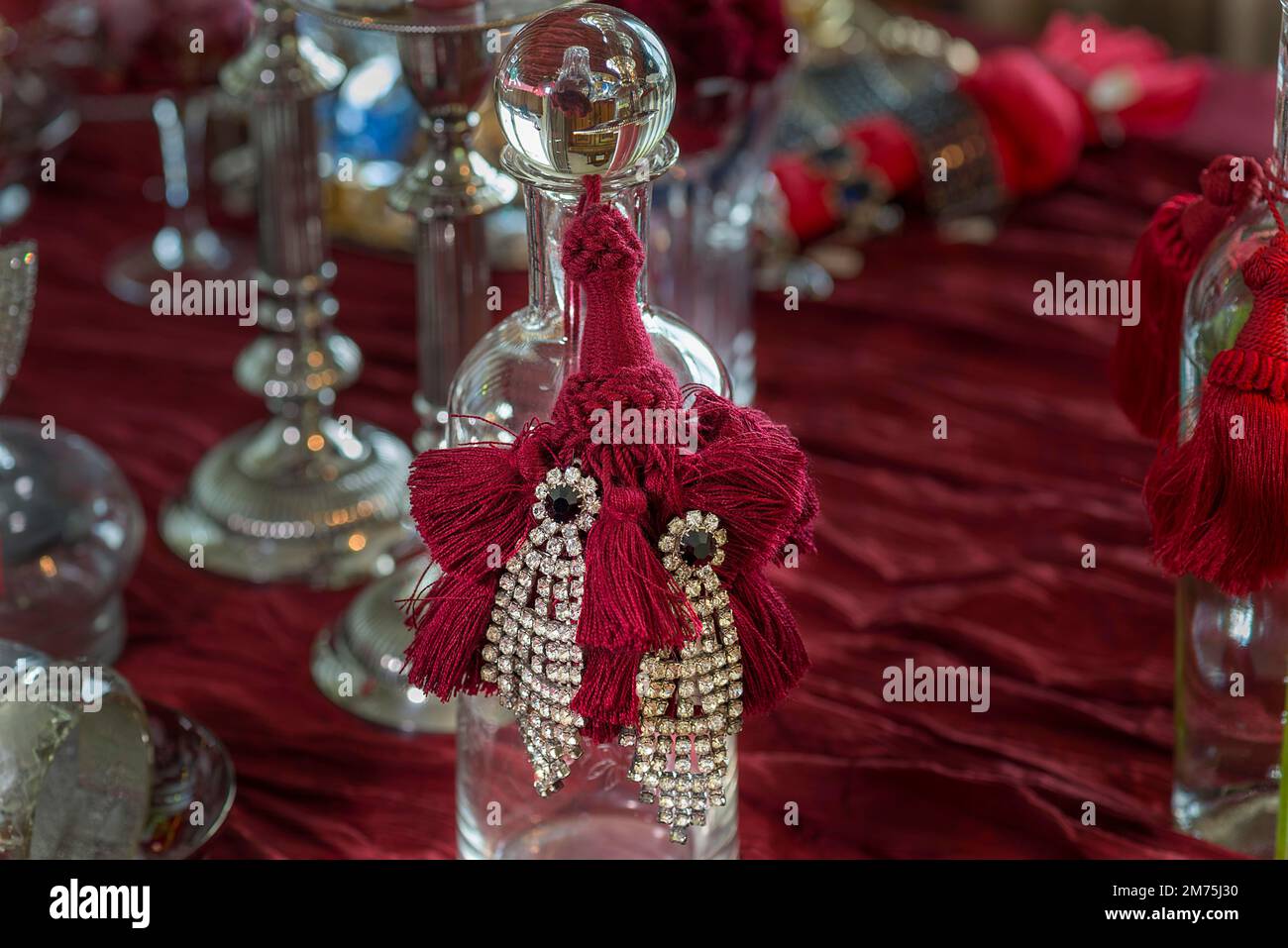 Orecchini in rhinestone decorati su una bottiglia di vetro, Baviera, Germania Foto Stock