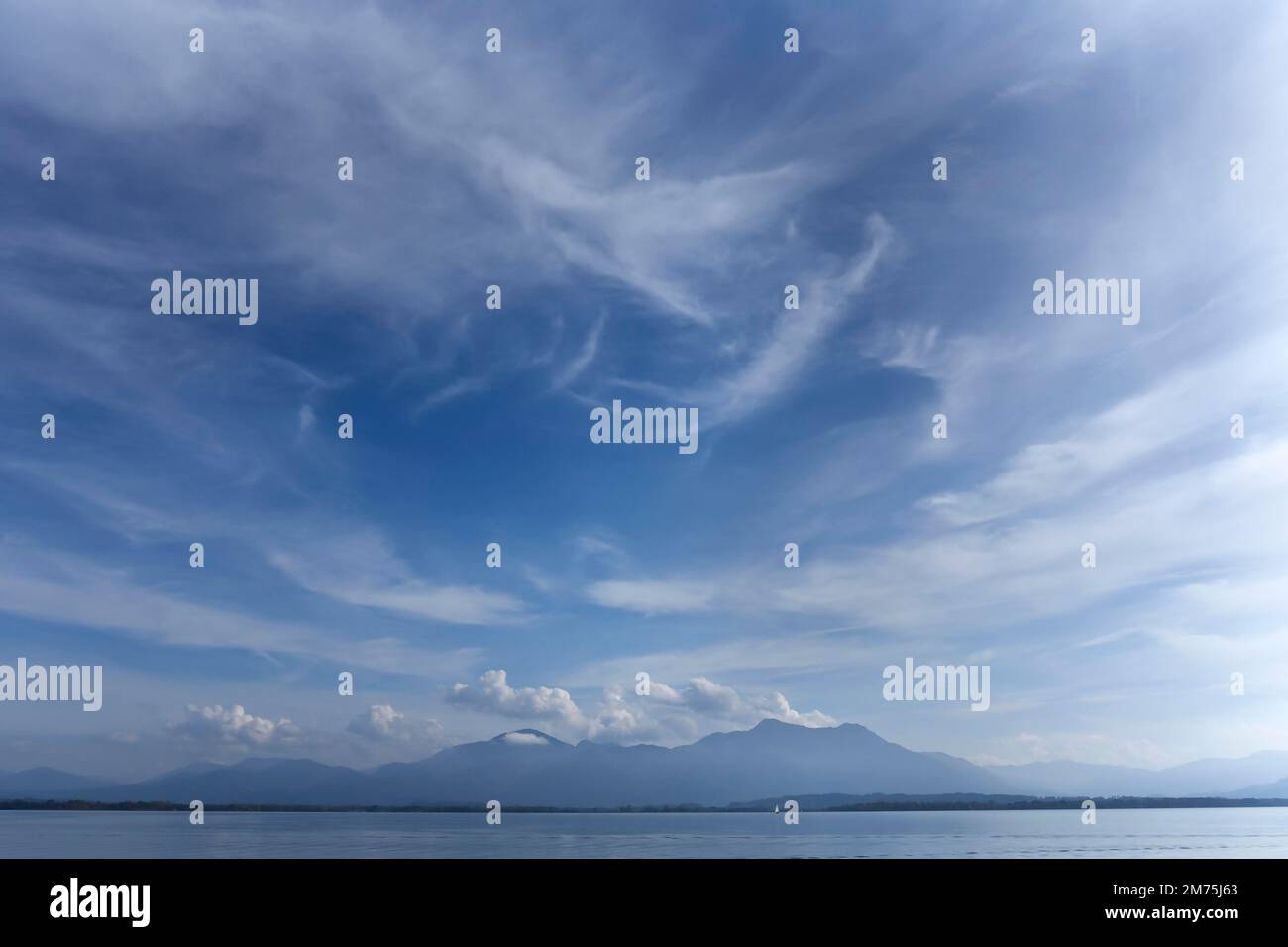 Cielo nuvoloso con il lago Chiemsee e le montagne Chiemgau, Gstadt. Baviera, Germania Foto Stock