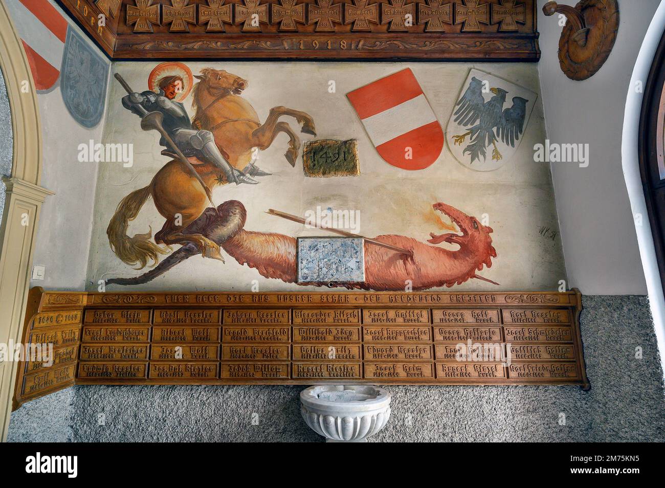 Memoriale di guerra con il murale Dragon Slayer, Chiesa parrocchiale cattolica, Maria-Opferung, Riezlern, Kleinwalsertal, Vorarlberg, Austria Foto Stock