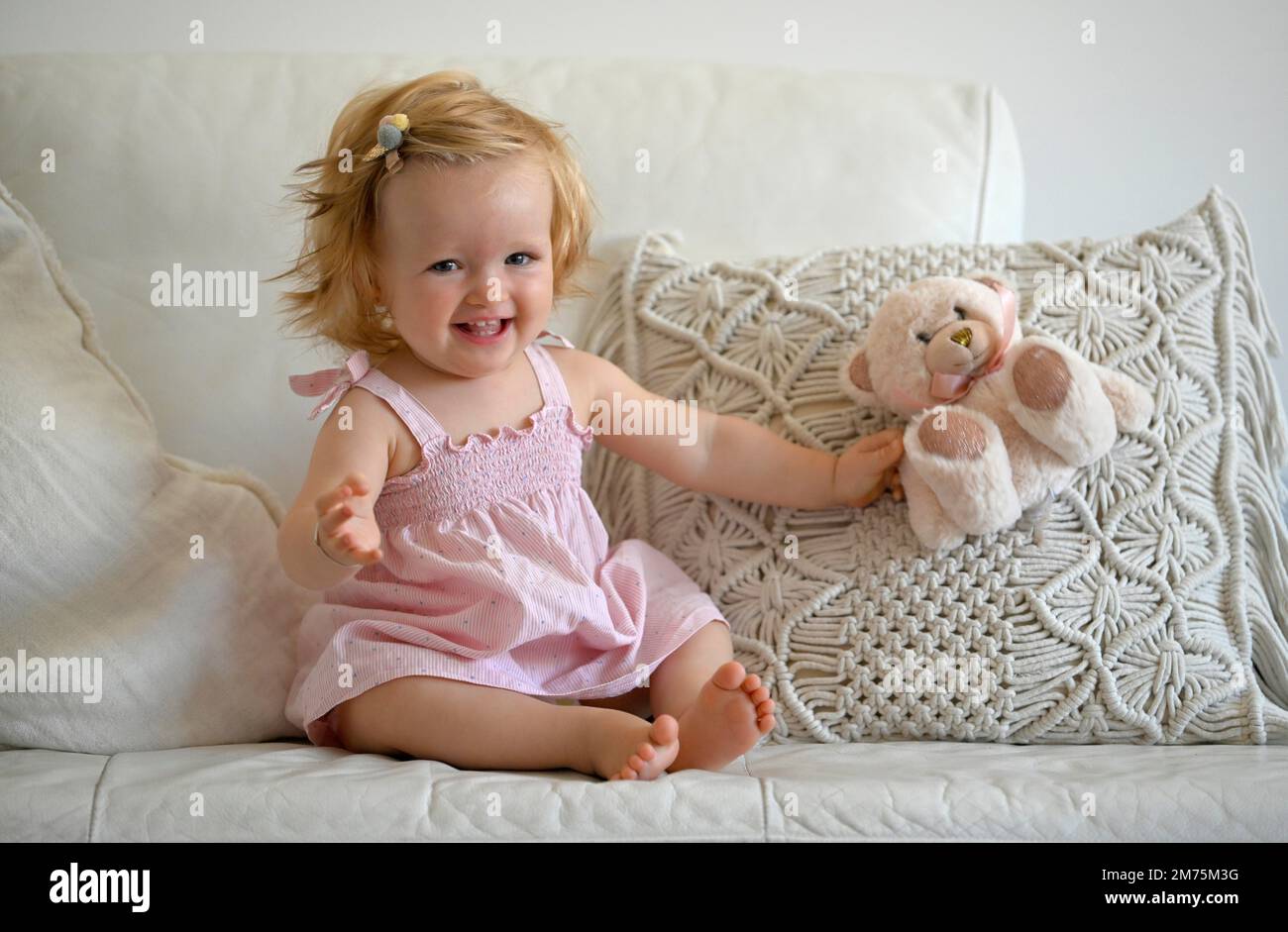 Ragazza, bimbo, 11 mesi, seduta sul divano, giocare con il peluche, Sorridente, Baden-Wuerttemberg, Germania Foto Stock