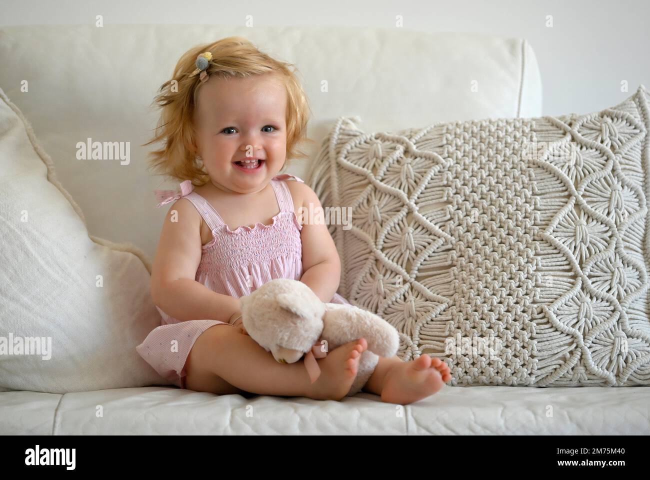 Ragazza, bimbo, 11 mesi, seduta sul divano, giocare con il peluche, Sorridente, Baden-Wuerttemberg, Germania Foto Stock