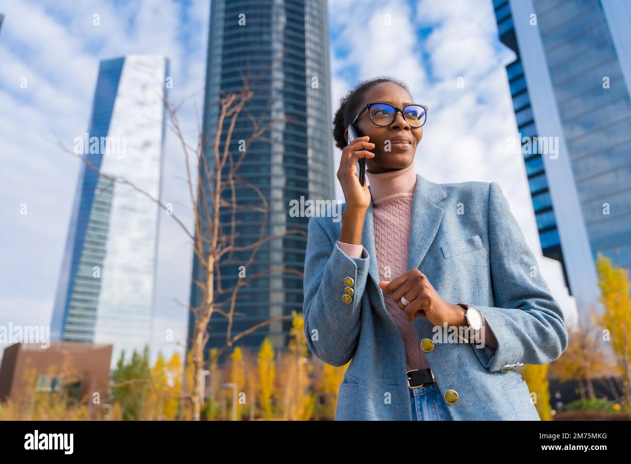 Ritratto aziendale di donna d'affari etnica nera, business Park, sorridente parlando al telefono Foto Stock