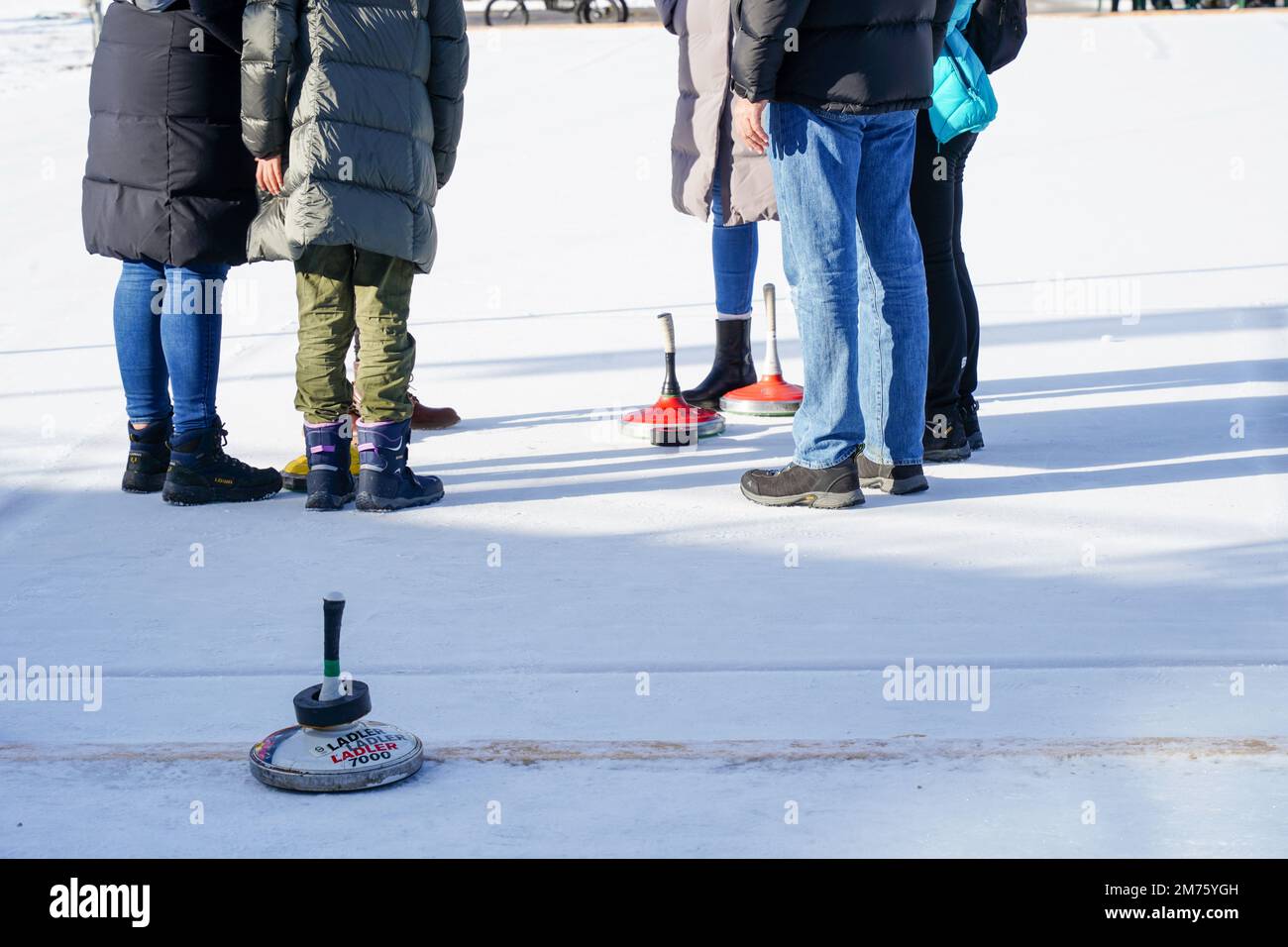 Seefeld, Austria - Dicembre 2022: Una famiglia ama fare una partita di curling sul ghiaccio nella località sciistica di Seefeld in Tirolo, Austria Foto Stock