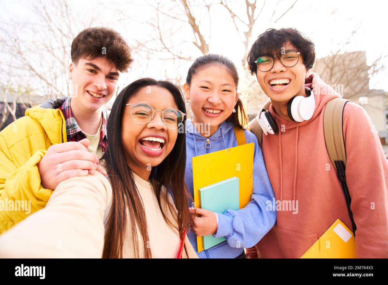 Selfie di quattro studenti internazionali con sorrisi via IR si stanno posando per scattare foto Foto Stock