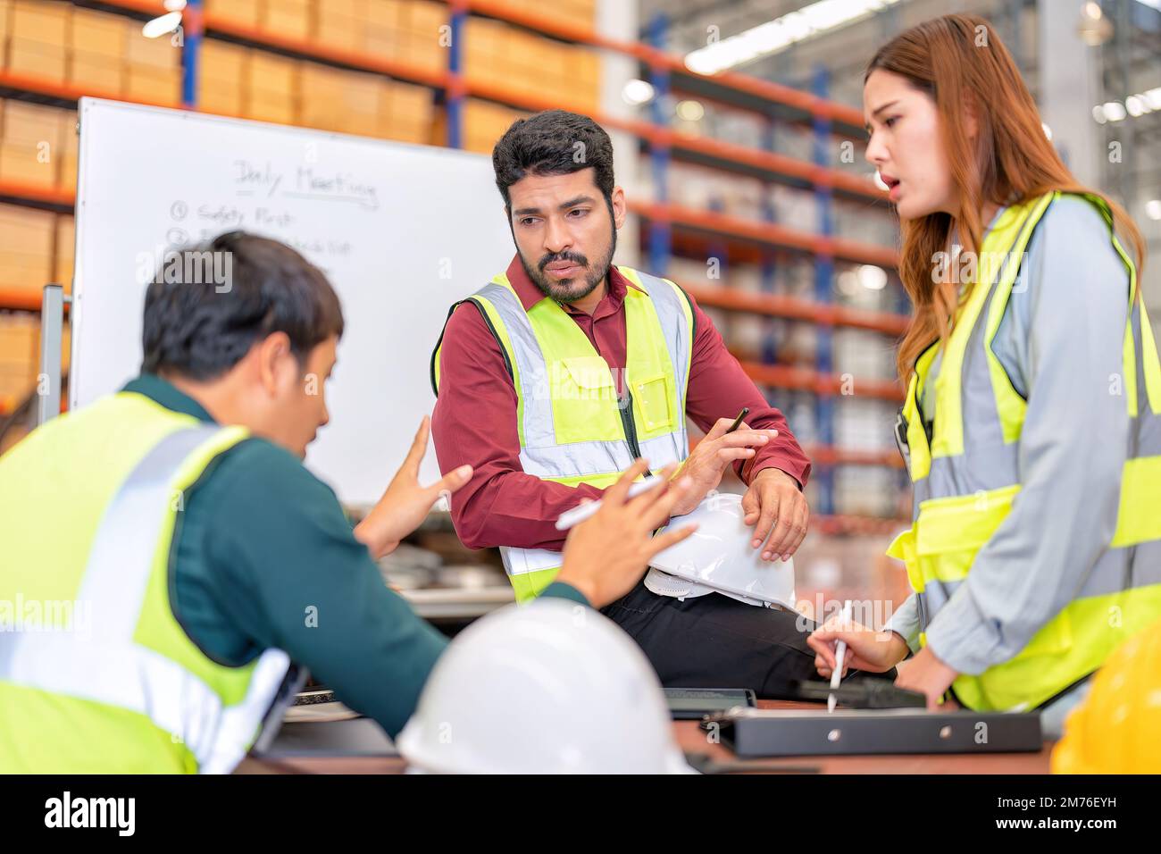 Il gruppo di lavoratori della fabbrica del magazzino conduce la cassetta degli attrezzi parlare riunione quotidiana e discussione brainstorming al mattino prima di iniziare a lavorare Foto Stock