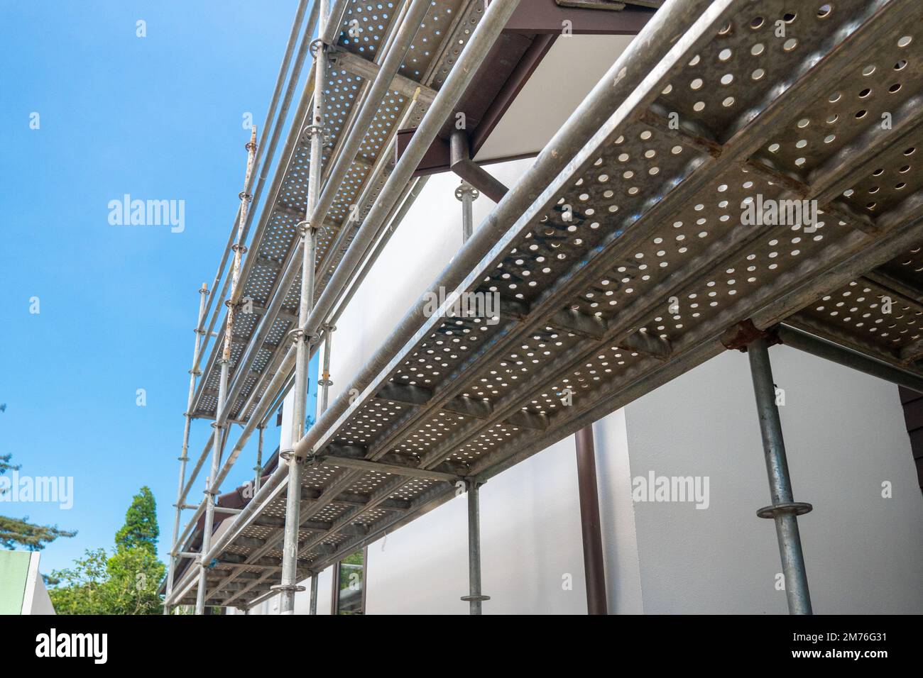 Moderna costruzione di casa con piattaforma impalcatura palo. Edificio domestico di nuova costruzione. Ponteggi e parti di montaggio in acciaio per una maggiore resistenza nella costruzione Foto Stock