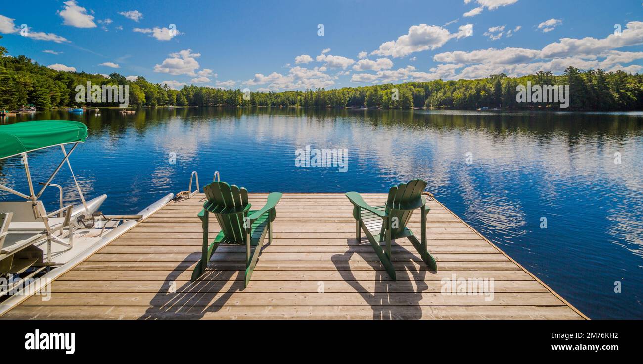 Due sedie Ontario seduti su un molo di un cottage in legno Foto Stock