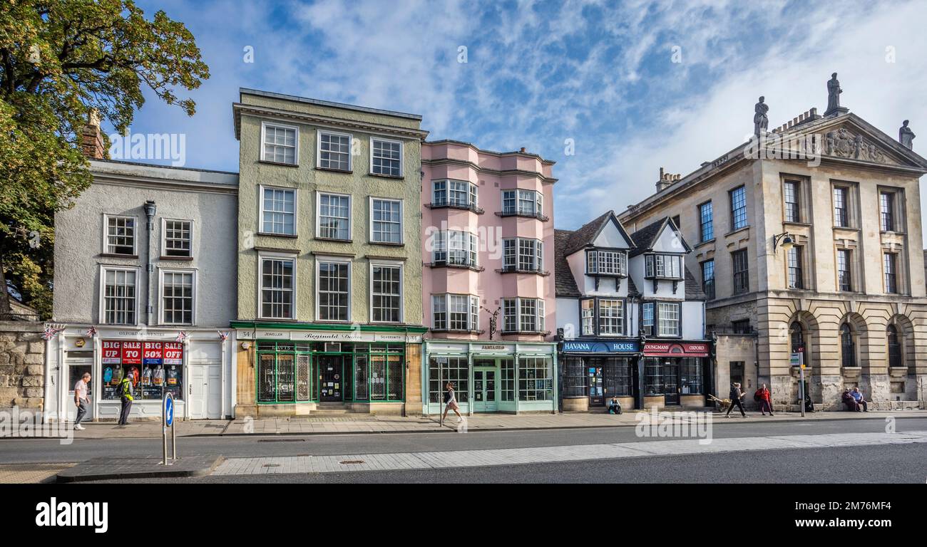 Le facciate dei negozi di Oxford High Street e l'ala ovest del Queens College, Oxfordshire, Inghilterra sudorientale Foto Stock