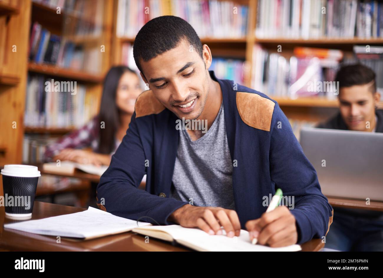 HES un allievo così diligente. un bel giovane studente che lavora diligentemente in classe. Foto Stock