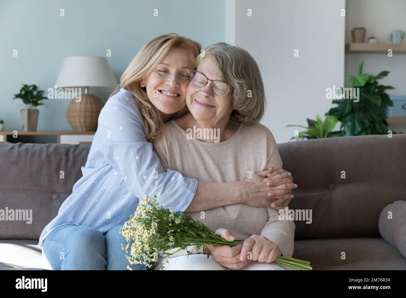 Felice pacifica cura anziana figlia donna abbracciare la mamma anziana Foto Stock