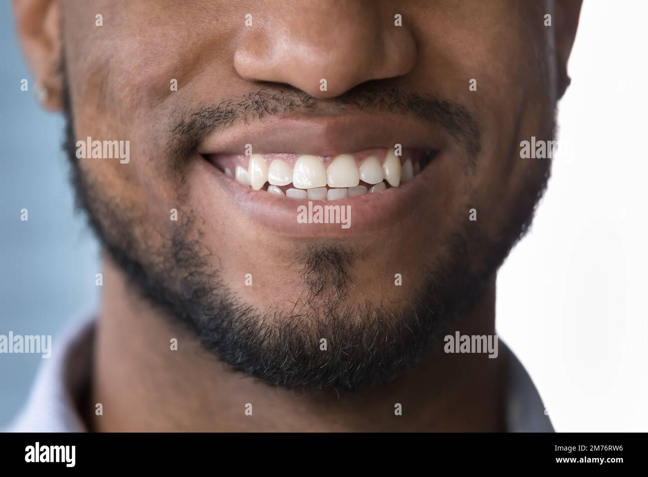 Primo piano raccolto faccia inferiore parte di un uomo africano sorridente Foto Stock