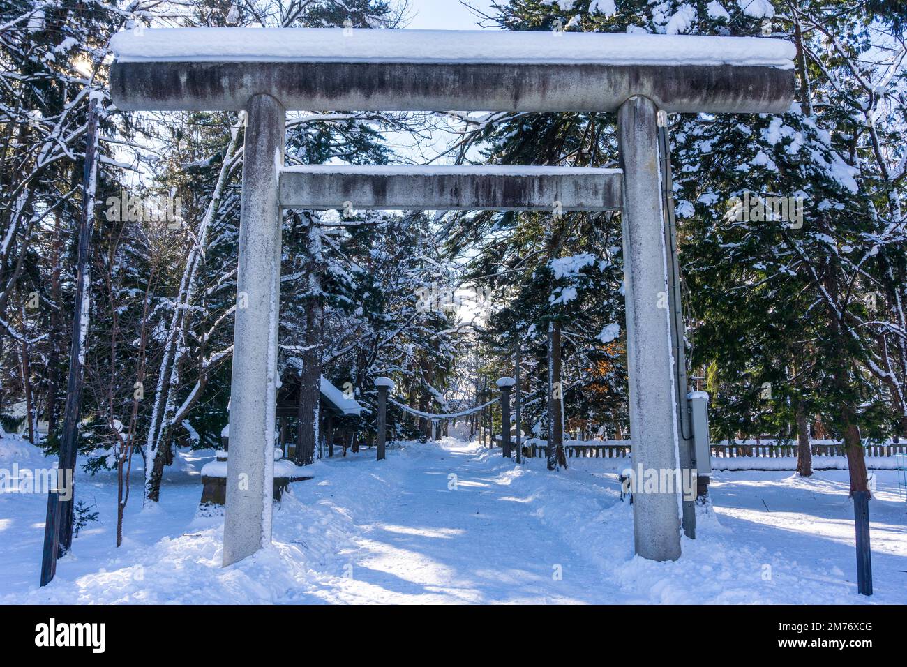 Vista della porta torii coperta di neve al santuario Higashikawa in una luminosa giornata invernale di Capodanno nella città di Higashikawa, Hokkaido, Giappone settentrionale Foto Stock