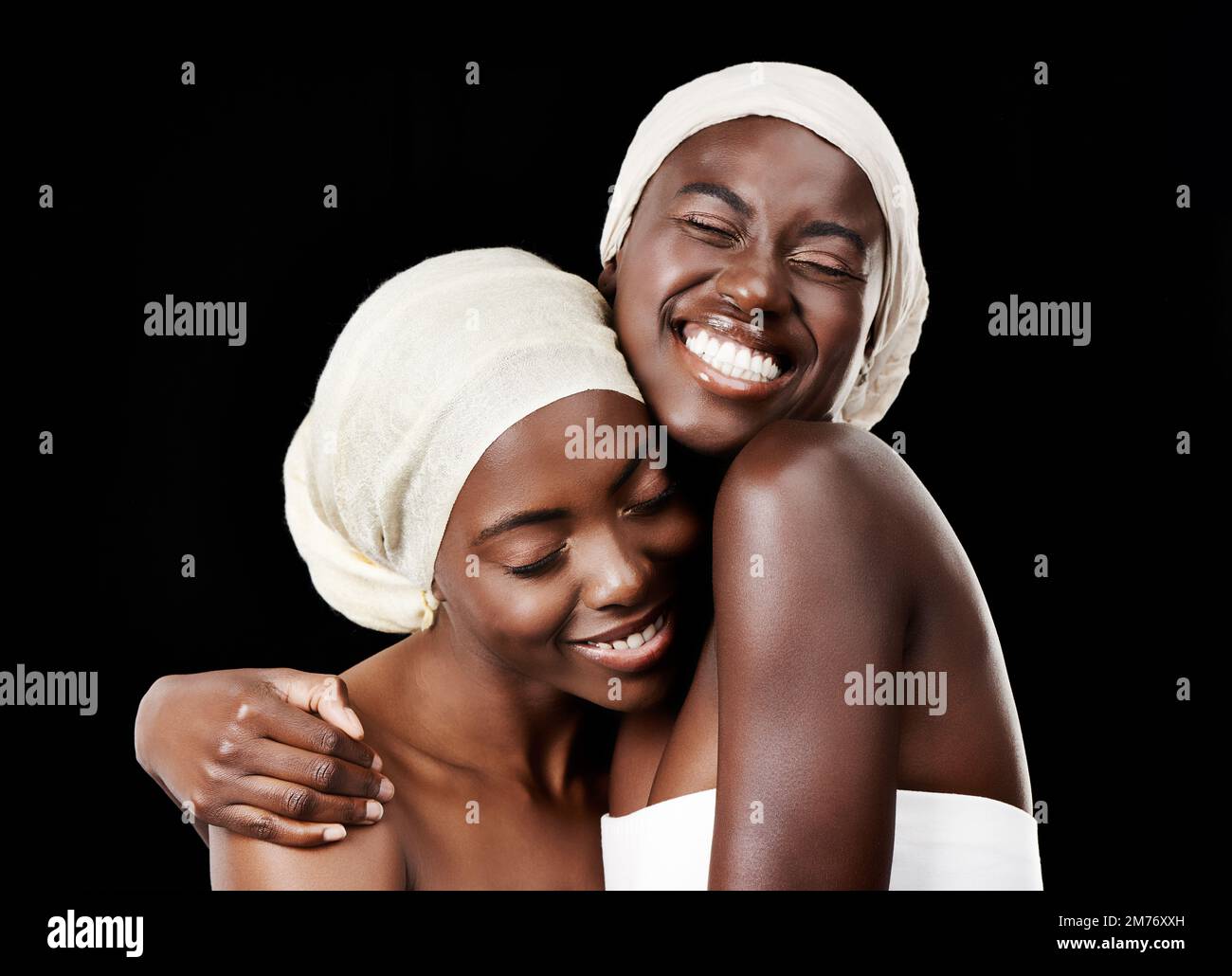 Avvolto in un bozzolo d'amore. Studio di due belle donne che indossano il velo su uno sfondo nero. Foto Stock