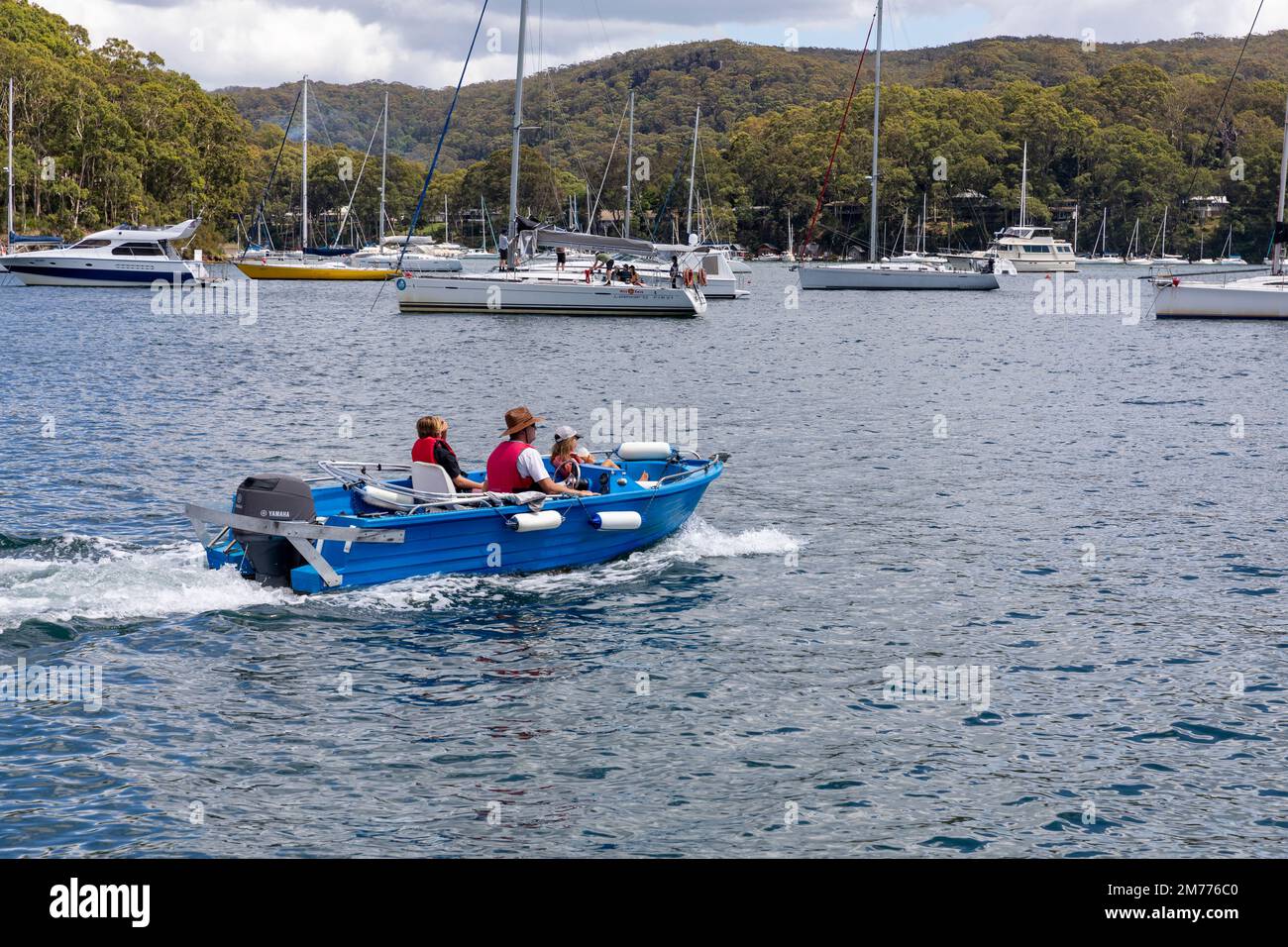 Padre e due bambini in una piccola barca run about policraft su Pittwater, visto da Church Point, yacht ormeggiati in background, Sydney, NSW, Australia Foto Stock