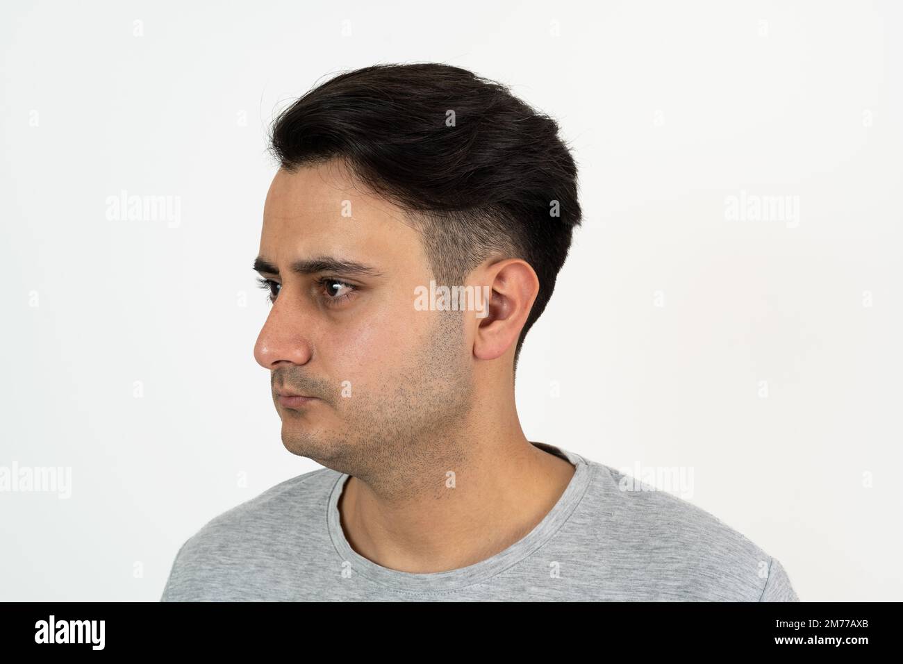 Ritratto di un uomo marrone con pelle e capelli neri ben curati e setosi su sfondo bianco isolato. Foto Stock