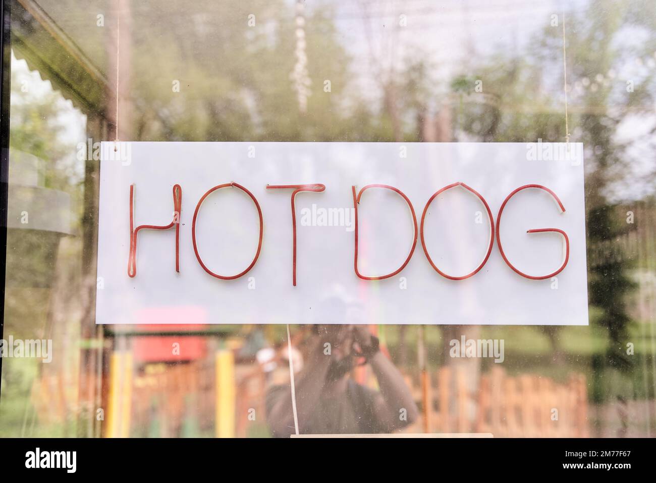 Cartello appeso con hot dog scritto dietro vetro Foto Stock