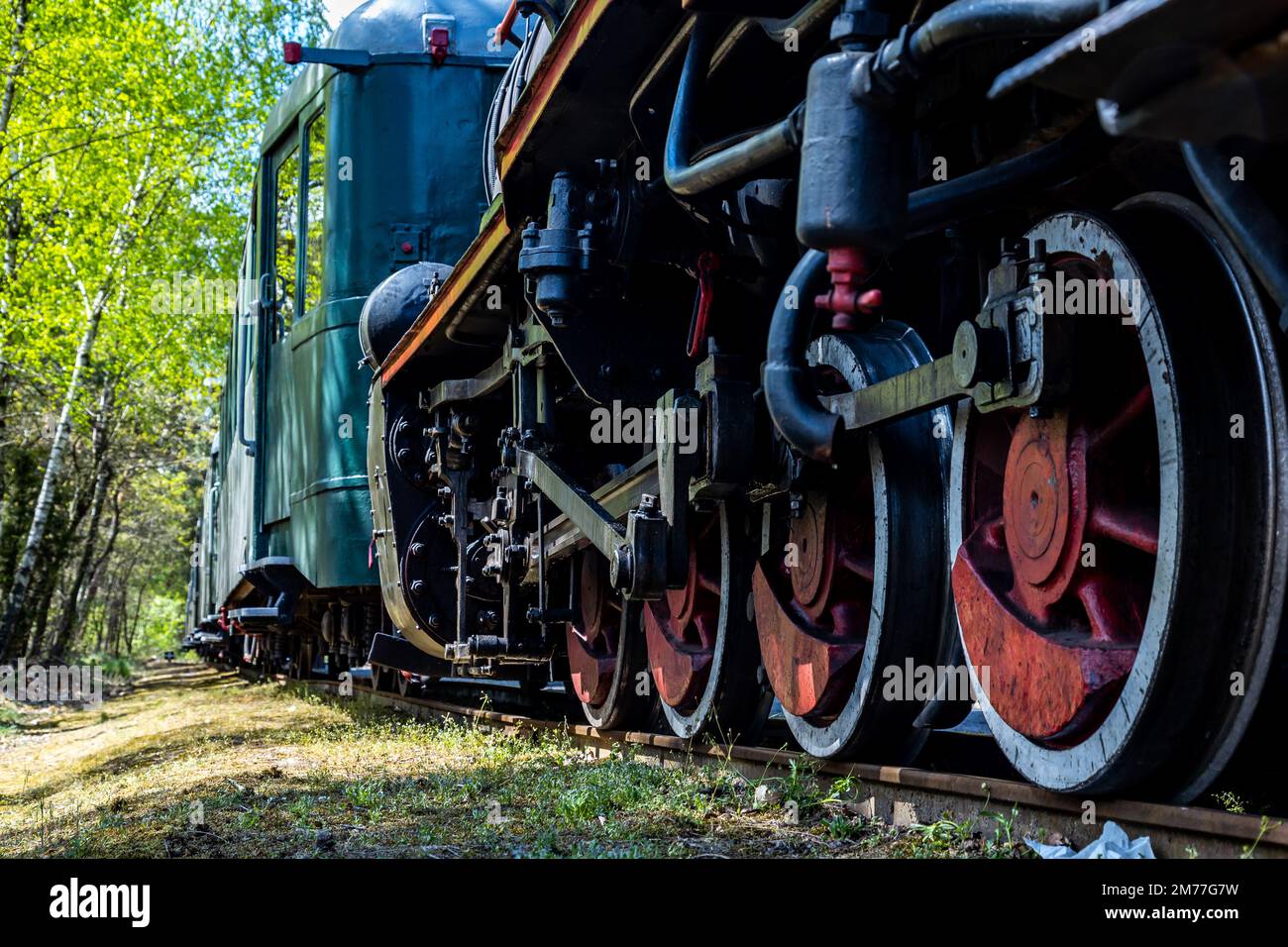 Primo piano delle ruote motrici di una locomotiva a vapore. Locomotiva a vapore parcheggiata sulla stazione forestale. Foto Stock