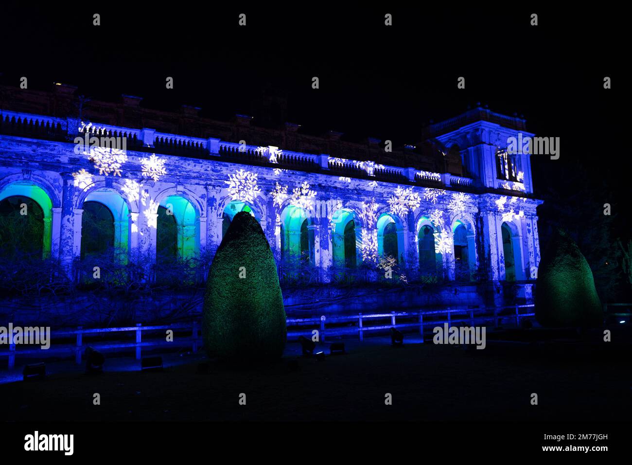 Edificio storico illuminato con luci di Natale blu e fiocchi di neve di notte Foto Stock