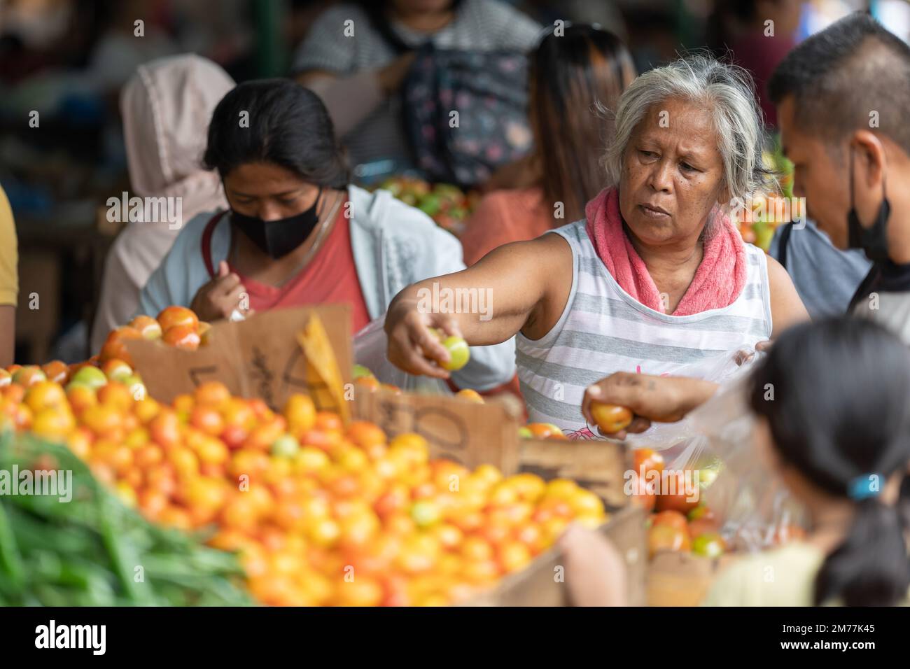 La gente che compra i pomodori freschi su una stalla del mercato, città di Cebu, Filippine Foto Stock