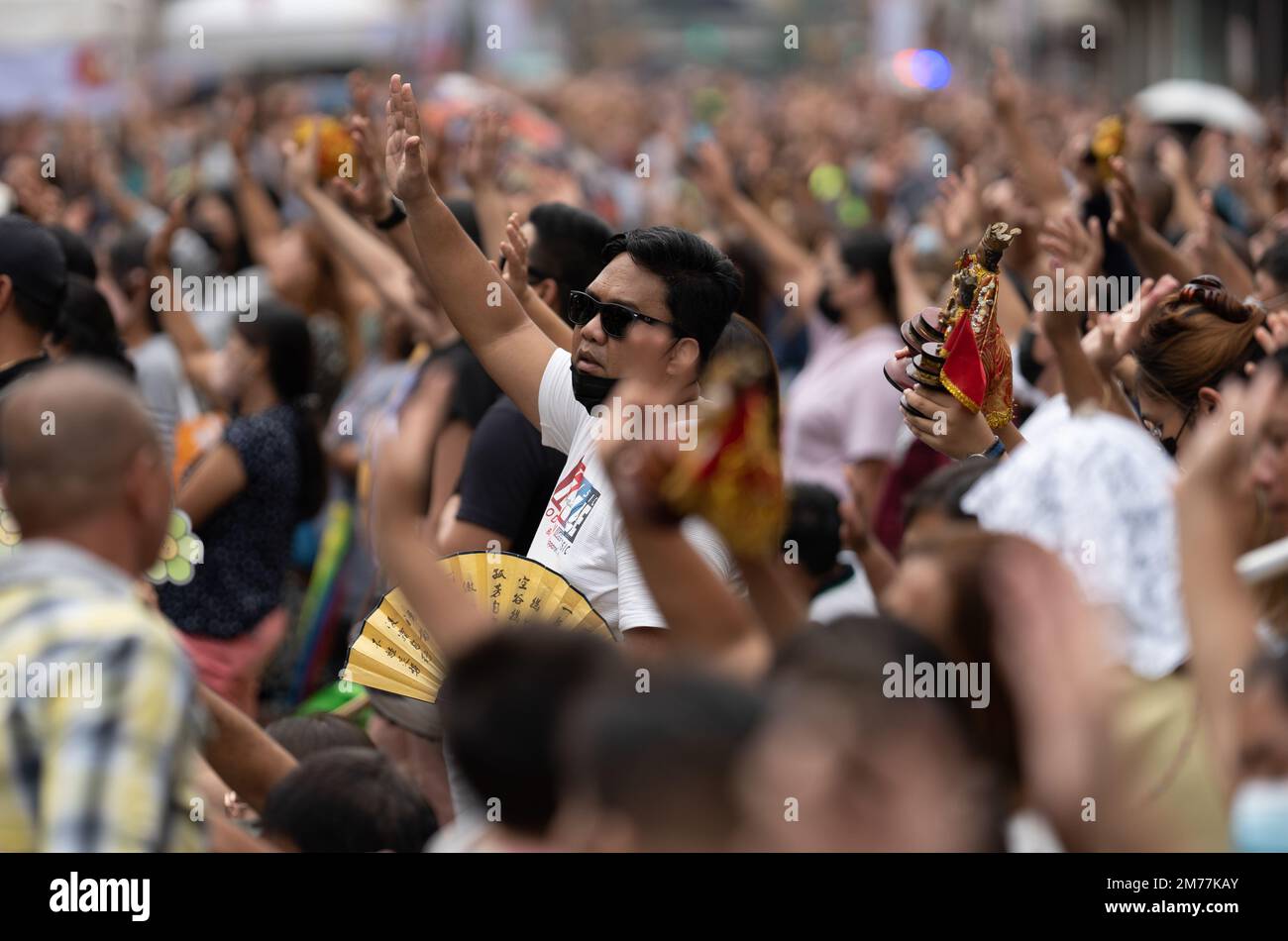 I cattolici filippini agitarono le mani in aria e sorreggono le statuine di Santo Nino mentre la canzone religiosa Batobalani sa Gugma viene suonata al B Foto Stock