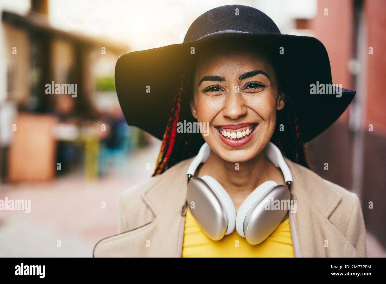 Mixed race girl ascoltare musica playlist con cuffie all'aperto - Focus on Face Foto Stock