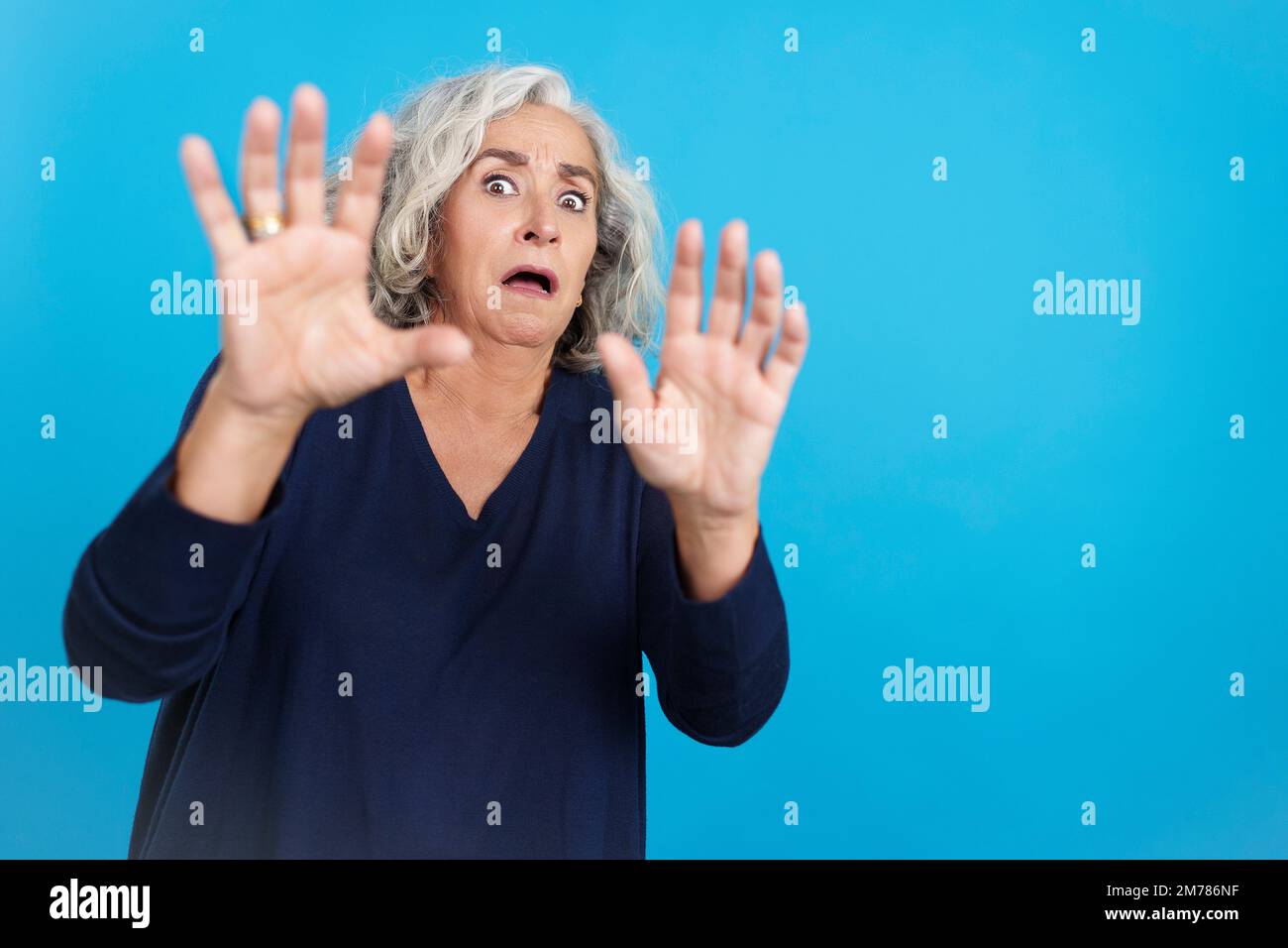 Donna matura che gestura con le mani nella paura Foto Stock