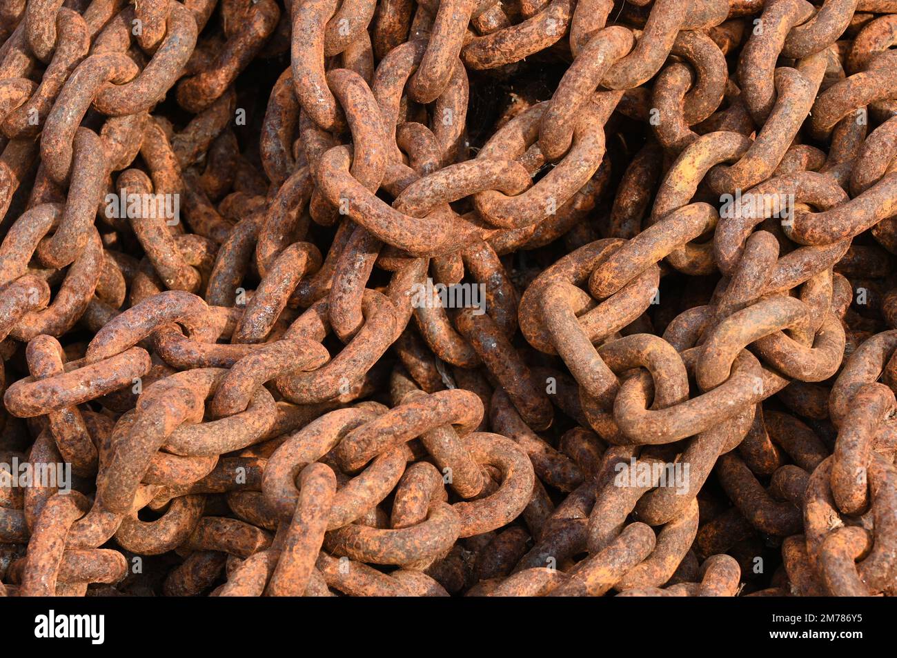 Catene intrecciate ruggine raffiguranti resistenza e decadimento nel contesto industriale Foto Stock
