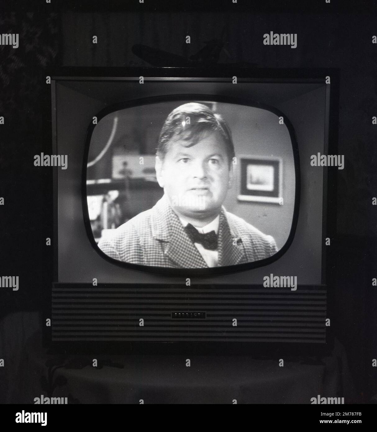 1957, storico, il comico Benny Hill sulla televisione della BBC che viene trasmesso su un televisore Briitsh Made Ferranti. Il Benny Hill Show è stato il primo broadacst della BBC nel 1955. Benny Hill sarebbe diventata una delle figure più popolari della televisione britannica, con uno dei suoi programmi del 1970s guardato da 21 milioni di spettatori. Fondata nel 1882, Lancashire ha sede a Ferraniti, è stata un'azienda leader nel settore delle valvole, della radio e della televisione, in seguito diventata una delle principali società britanniche di ingegneria elettrica. La divisione radio e televisione fu venduta alla rivale ECKO nel 1957. Foto Stock
