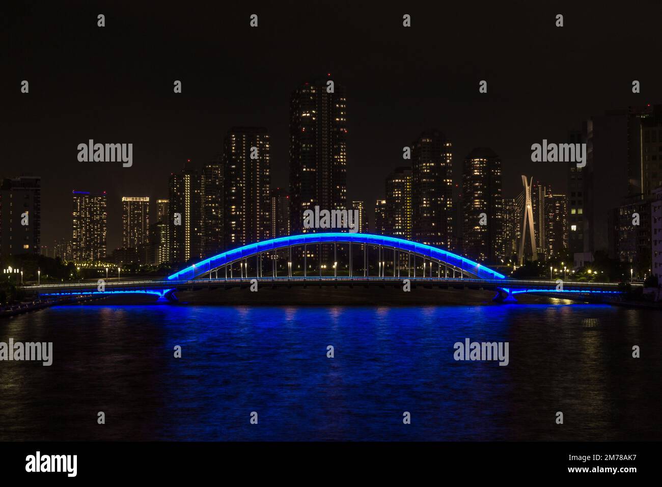 Vista notturna del Ponte Eitai sul fiume Sumidagawa, con alti edifici dietro, Tokyo, Giappone. Foto Stock
