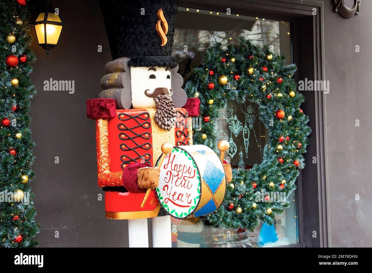 Sfondo delle vacanze di Natale con il giocattolo nutcracker e la vetrina decorata. Acquisto di regali e souvenir per le festività invernali. Mercatino di Natale. Foto Stock